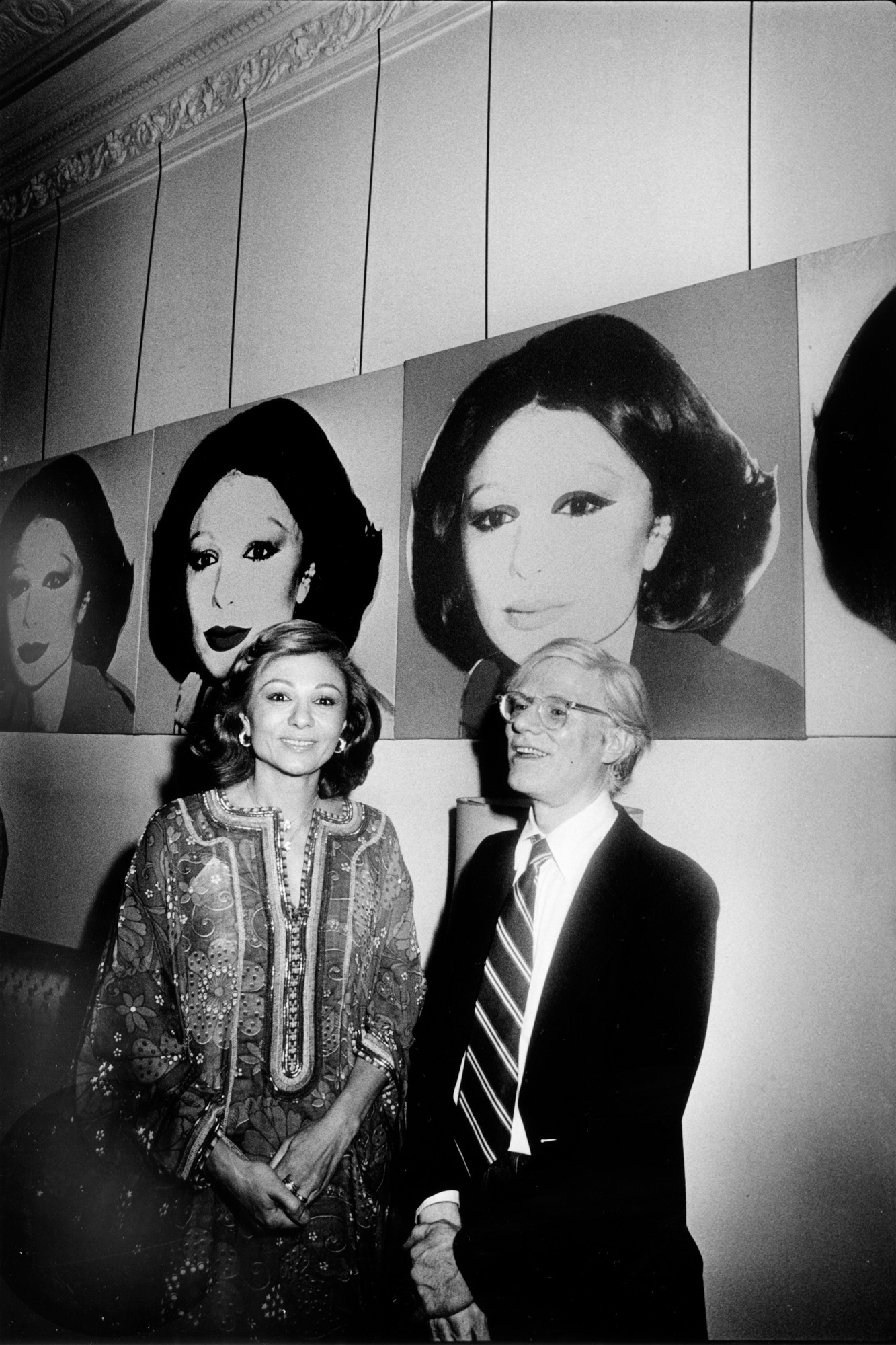 Andy Warhol con la emperatriz Farah Pahlaví en una exposición de su obra en las vías de tren secretas bajo el Waldorf Astoria - 1965